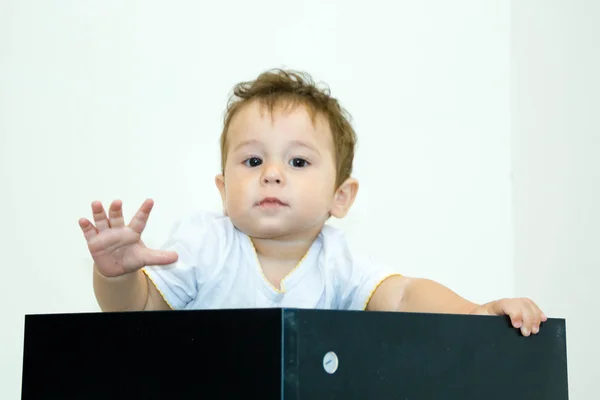 Un jeune garçon qui regarde hors d'une boîte sur un fond blanc — Photo