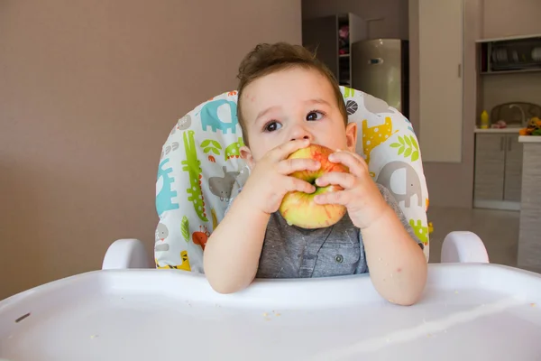 Imádnivaló baba fiú étkezési alma. első élelmiszer-10 hónapos babák. totyogó fiú megtanulni élni a fogak szilárd étel — Stock Fotó