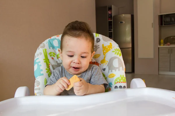 Portrait cute baby boy eating child biscuit the first food for babies 10 months. toddler boy learning to live with teeth solid food — Stock Photo, Image