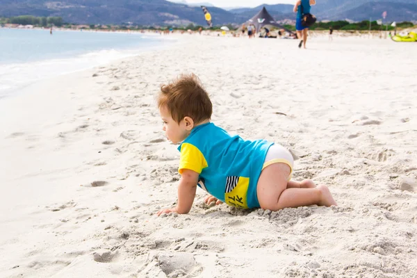 Bayi laki-laki kecil mengenakan pakaian penjaga ruam biru bermain di pantai laut tropis. UV dan perlindungan matahari untuk anak-anak kecil. Anak Toddler selama liburan laut keluarga. Air musim panas menyenangkan . — Stok Foto