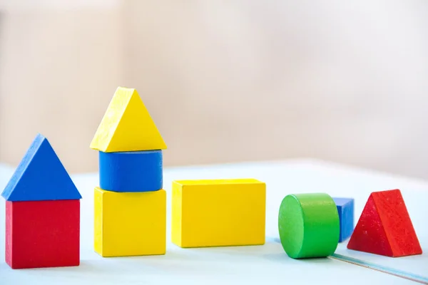 House made of old cubes. Wooden colorful building blocks. Vintage childrens toys. the concept of building a house, apartments for sale