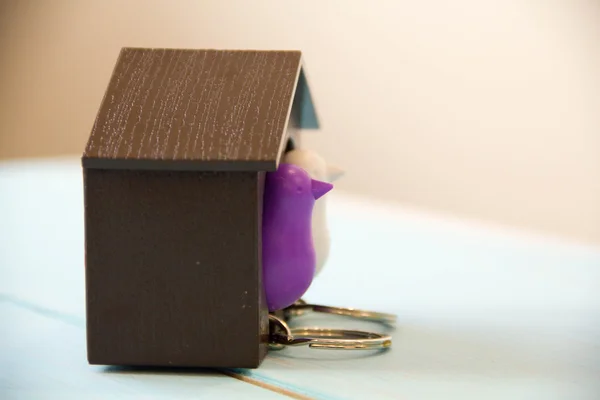 Κλειδί σπίτι σε ένα σπίτι σε σχήμα μπρελόκ ξύλινο τραπέζι. Έννοια για την ακίνητη περιουσία ή νοικιάζοντας το σπίτι. — Φωτογραφία Αρχείου