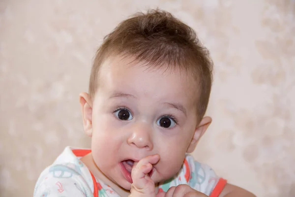 Fiú sírt és harapás az ujjait, mászni az első fogak. egy 7 hónapos baba nő — Stock Fotó