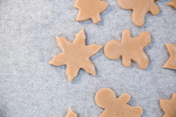 Weihnachtsplätzchen. Backen. Teig ausrollen, um Sterne auf einem hölzernen Hintergrund zu schneiden — Stockfoto