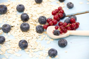 Taze çilek ahududu, frenk üzümü, ahşap masa üzerinde cam kapta yaban mersini