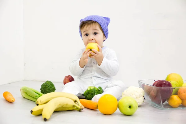 El bebé en un ambiente de las verduras frescas, aislado en el blanco — Foto de Stock