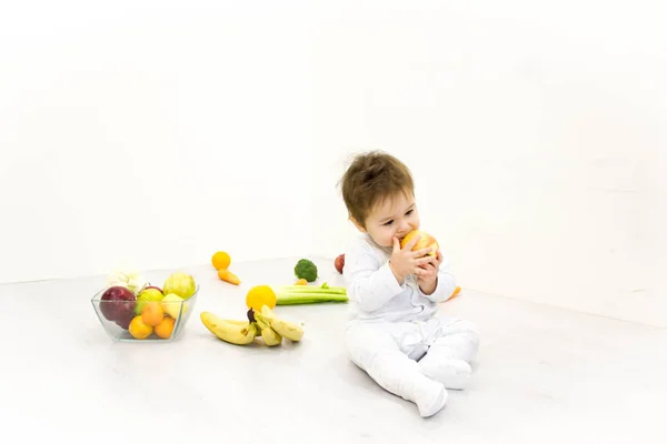 El bebé en un ambiente de las verduras frescas, aislado en el blanco — Foto de Stock