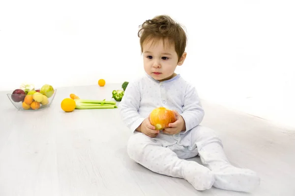 Bebé rodeado de frutas y verduras, nutrición infantil saludable — Foto de Stock