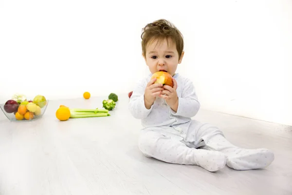 Bebé sonriente comiendo plátano y muchas clases de fruta y tazón con yogur — Foto de Stock