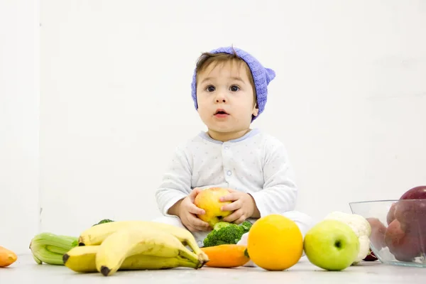 Bebé rodeado de frutas y verduras, nutrición infantil saludable — Foto de Stock