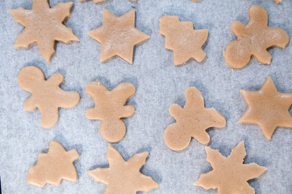 Weihnachtsplätzchen. Backen. Teig ausrollen, um Sterne auf einem hölzernen Hintergrund zu schneiden — Stockfoto