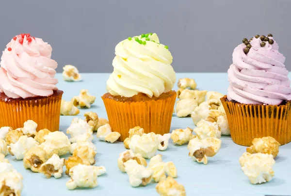 Cupcakes coloridos em um fundo de madeira — Fotografia de Stock