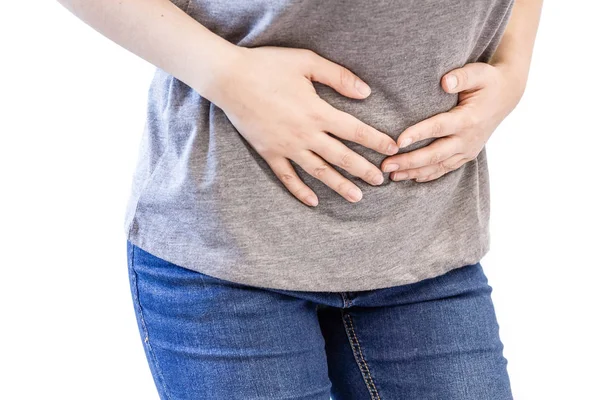 Mujer joven con problemas de estómago. mujer blanca camisa deportiva dolor de estómago y la mano en el abdomen. dolor de menstruación o dolor de estómago, mano sosteniendo el vientre de cerca — Foto de Stock