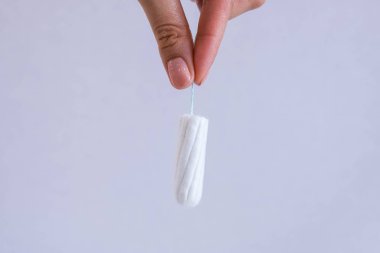 Temiz pamuk tampon yakın çekim tutan kadının el. Genç kadın Hayız zaman hazırlanıyor. Yumuşak koruma kadın kritik gün, jinekolojik ihale. Tıbbi hijyen anlayışı ve koruma