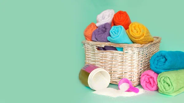 Pink plastic measuring vessel with washing powder, containers with detergent, stack terry towels — ストック写真