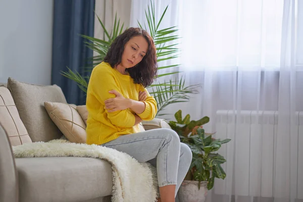 Žena trpí depresí, sedící na posteli v pyžamu — Stock fotografie