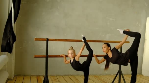 Δάσκαλος αργής κίνησης του κλασικού χορού διδάσκει μερικά βήματα στο νεαρό μαθητή του που θέλει να μάθει πώς να χορεύει και στο παρασκήνιο τα άλλα μικρά κορίτσια που ακούνε. — Αρχείο Βίντεο