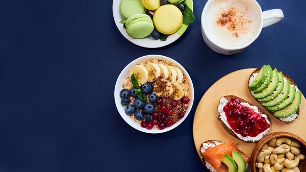 朝食のトップビューブラックの背景。ベリーのオートミールや木のトレイのトーストナッツコーヒー — ストック写真