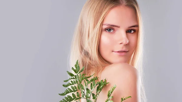 Soin naturel bio de la peau, concept d'harmonie avec la nature, la fougère verte laisse de l'herbe près du visage. portrait de dames de beauté. Jeune belle femme avec une peau propre et pétillante du visage et du corps. — Photo