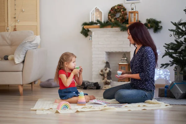 Portrait d'une mère et sa fille, maman et sa fille jouent sur le sol à la maison. Nouvel An ou intérieur de Noël — Photo