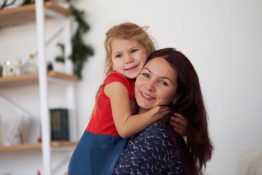 Anne ve kızı evde sarılıyorlar.