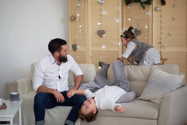 Папа и дети веселятся вместе, папа смотрит, как сын и дочь играют на диване — стоковое фото