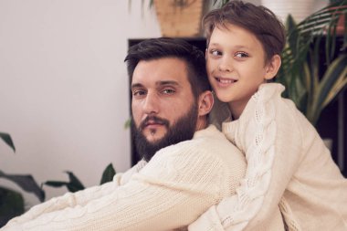 Baba ve oğul kameraya bakıyor. Babam çocuğu sırtımda taşıyorum. Kapat.