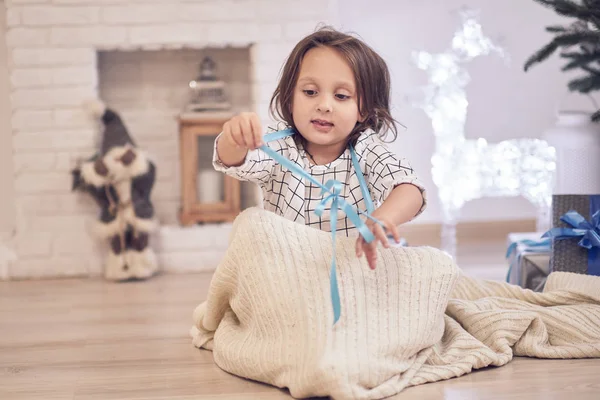 Little girl under the tree with gifts. cute girl is playing under the christmas tree — Stock Photo, Image