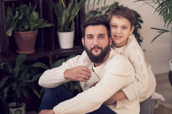 Father and son looking at camera. Dad giving piggyback ride to the boy. close up