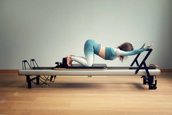 Treino de pilates leotard. exercícios de reforma pilates atléticos. pilates equipamento de máquina. jovem asiático mulher pilates alongamento esporte no reformador cama instrutor menina no um estúdio — Fotografia de Stock