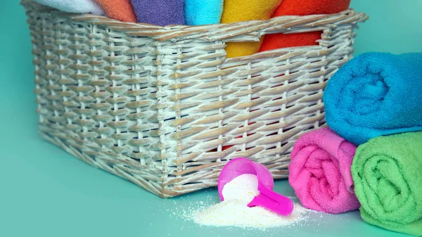 Recipiente de medición de plástico rosa con polvo de lavado, recipientes con detergente, toallas de rizo apiladas — Foto de Stock