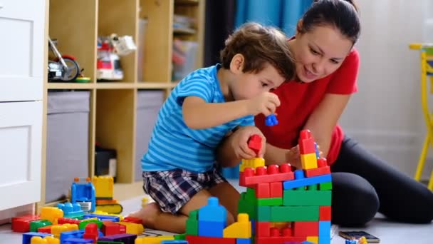 Anya játszik színes műanyag blokkok játék a fiával, koncepció anya és fia játszik együtt. — Stock videók