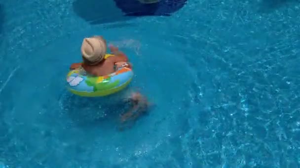 Junge schwimmt auf einem aufblasbaren Kreis im Pool, Zeitlupenvideo — Stockvideo