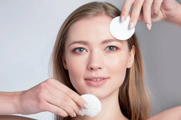 Fille fraîche saine démaquillant son visage avec du coton. femme avec une éponge wihte fond coton pad problème peau — Photo