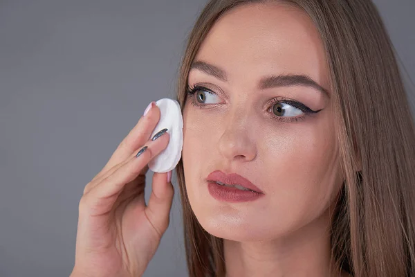 Ein gesundes frisches Mädchen entfernt ihr Gesicht mit einem Wattepad. Frau mit Schwamm mit Hintergrund Baumwollkissen Problemhaut — Stockfoto