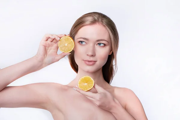 Πορτρέτο της όμορφης νεαρής γυναίκας κρατώντας φέτες πορτοκαλιού, περιποίηση προσώπου — Φωτογραφία Αρχείου