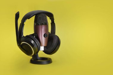 modern microphone and headphones on the yellow background, isolated on yellow clipart