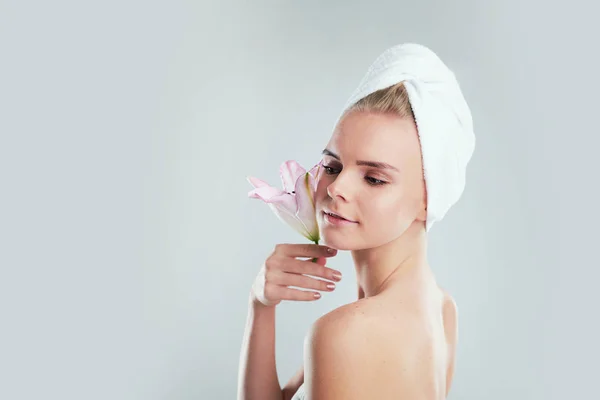 Clean Fresh Skin. Skin care concept. Young Woman. Beautiful young girl. Photo of blonde girl with Lily on grey background. — Stock Photo, Image