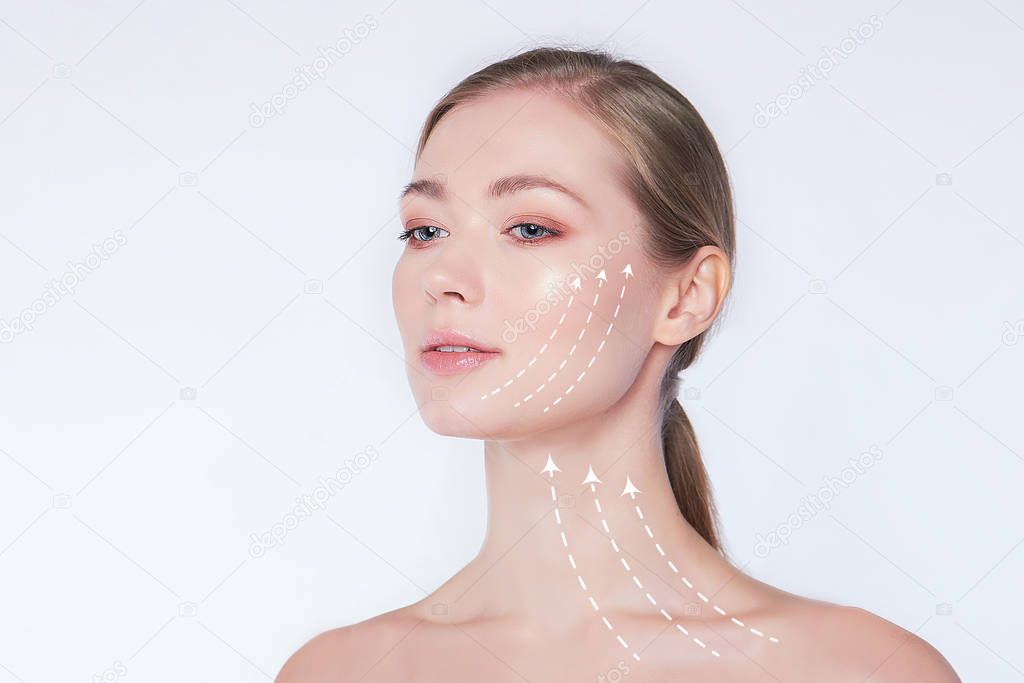 Close-up portrait of young, beautiful and healthy woman with arrows on her face spa, surgery, face lifting and make-up concept.