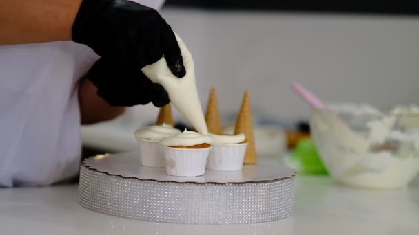 Decorar pastel de taza con crema. Pastelería haciendo cupcakes para la fiesta . — Vídeos de Stock