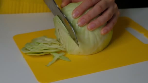 Woman finely cuts cabbage with a cleaver for the kitchen, close-up. Slow motion. — Stock Video