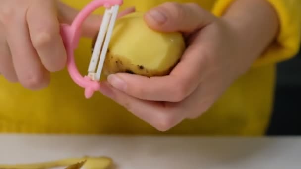 Hände schälen Kartoffeln in der Küche. Nahaufnahme. Zeitlupe. — Stockvideo