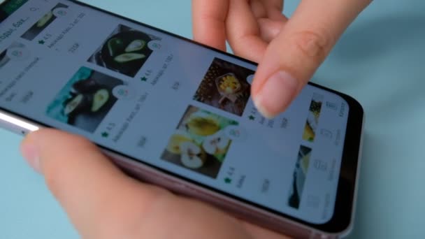RÚSSIA, Moscou - JANEIRO 2020. Smart phone compras online. Mulher pede comida para casa em uma loja online usando um smartphone. Feminino seleciona as maçãs de frutas na mercearia loja online. Close-up . — Vídeo de Stock