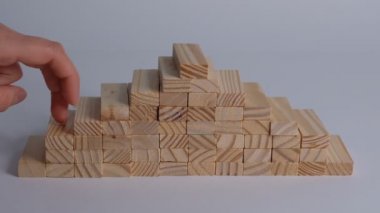 Üst katta beyaz arka planda yürümeyi taklit eden yığınla küp ve kadın eli. İlerleme kavramı. Yakın çekim Yavaş çekim.