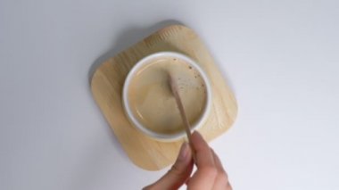 Kişi el direksiyonlu kahveyi kaşıkla içer. Beyaz arka planda, bir fincan sıcak, sade kahvenin kahvaltısı. Yakın çekim Yavaş çekim.