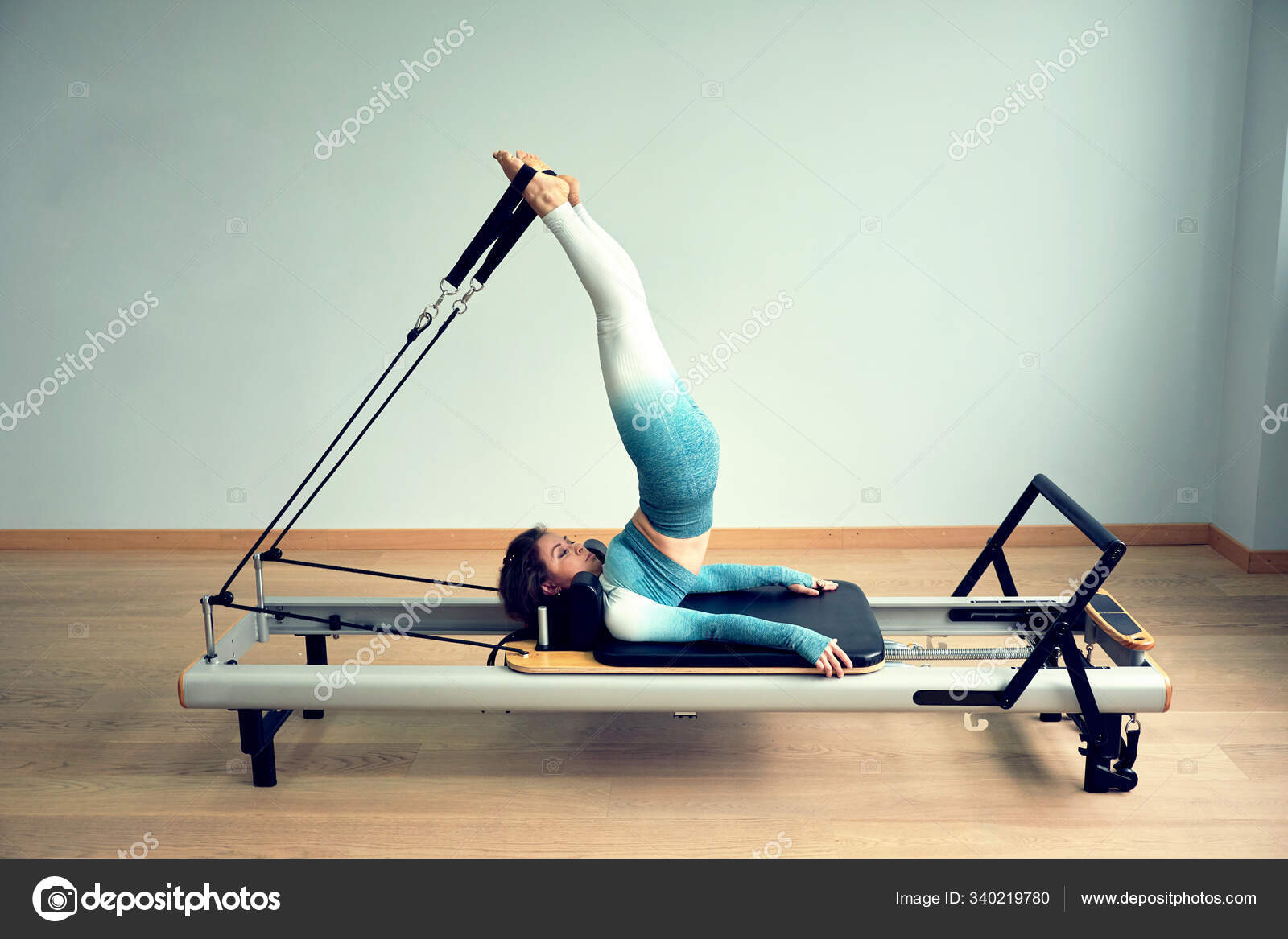 Young asian woman pilates stretching sport in reformer bed