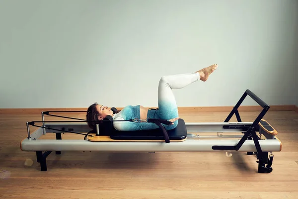 Giovane donna asiatica pilates stretching sport in riformatore letto instructor ragazza in un studio — Foto Stock