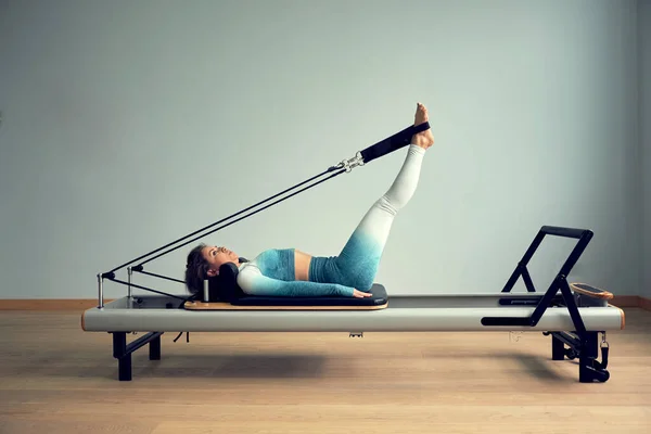 Giovane donna asiatica pilates stretching sport in riformatore letto instructor ragazza in un studio — Foto Stock