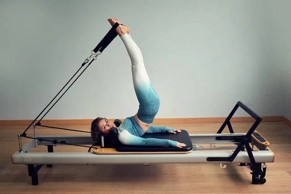 Joven asiático mujer pilates estiramiento deporte en reformador cama instructor chica en un estudio — Foto de Stock