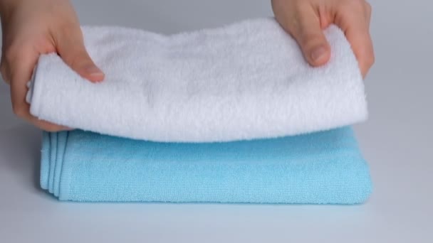 Primer plano de las manos poniendo pila de toallas de baño frescas en la sábana. Servicio de habitaciones limpieza limpieza habitación de hotel macro — Vídeo de stock